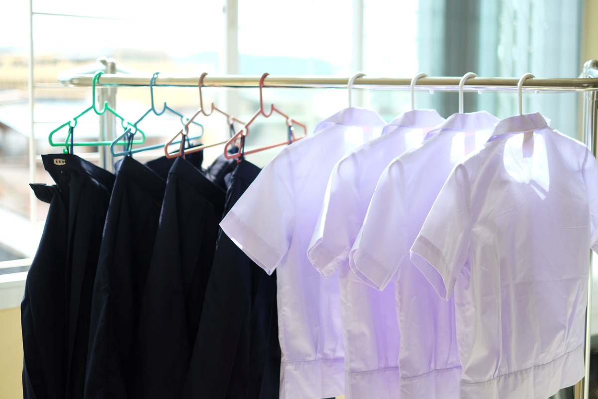 School uniforms hanging on a clothesline after a thorough wash.