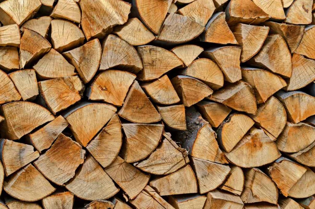 A steady amount of neatly stacked firewood on a rack outdoors.